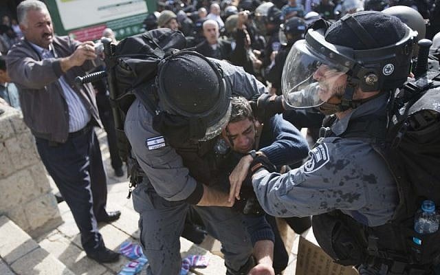 Israeli policemen arrest a Palestinian man during a demonstration in support of the people of Gaza and against Israel's military operations in the Strip, at the Damascus Gate in Jerusalem's Old City on Friday. (photo credit: Yonatan Sindel/Flash90)