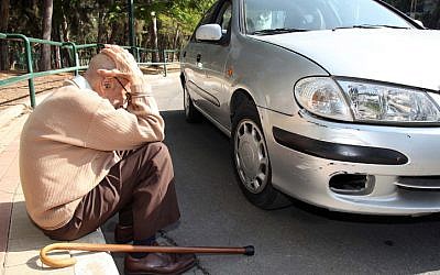 An elderly Israeli man takes cover on the sidewalk as a warning siren sounds signaling a rocket attack, in the area of Tel Aviv. November 18, 2012. (photo credit: Gideon Markowicz/FLASH90)