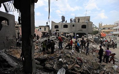Palestinians view the rubble of a destroyed home after Israeli air force rockets hit a Hamas official's house in the northern Gaza Strip on 17 November 2012. (photo credit: Wissam Nassar/Flash90)