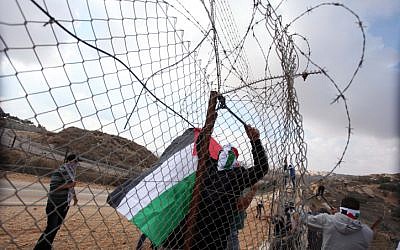 Palestinians cut through the fence along the 443 highway (photo credit: Issam Rimawi/Flash90) Palestinians cut through the fence along the 443 highway (photo credit: Issam Rimawi/Flash90)