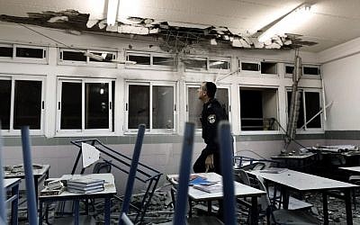 Police examine a classroom in Ashkelon damaged by rocket fire. (photo credit: Tsafrir Abayov/Flash90)