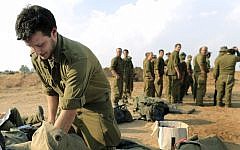 An Israeli reserve soldier packs his bag before leaving a deployment area near the Gaza border, November 2012. (Tsafrir Abayov/Flash90)