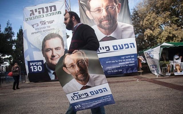 A Likud supporter carries a poster of far-right party member Moshe Feiglin (Uri Lenz/Flash90)
