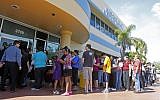 Voters stand in line to pick up their absentee ballots in Doral, Fla., Sunday, Nov. 4, (photo credit: AP/Alan Diaz)