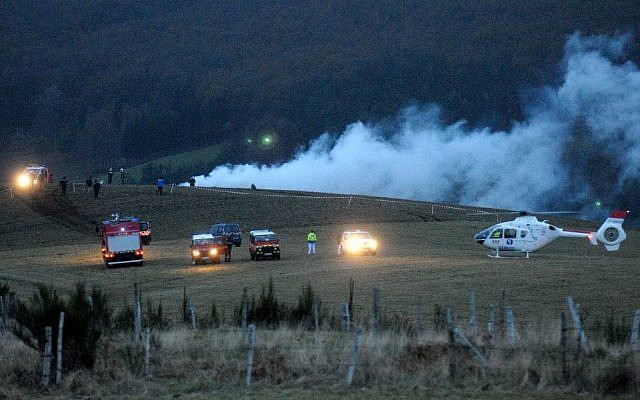 Police, firemen and a medical helicopter near the Algerian military cargo plane crash scene, in Trelans, southern France, on Friday. The plane went down with six people aboard, according to local police. (photo credit: AP Photo/Eva Koord)