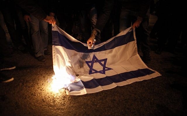 Illustrative photo of protesters burning an Israeli flag during a protest against Israel's attacks of the Gaza Strip. (AP/Kostas Tsironis) Illustrative photo of protesters burning an Israeli flag during a protest against Israel's attacks of the Gaza Strip. (AP/Kostas Tsironis)