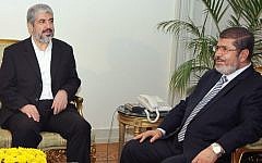In this image provided by the Egyptian President, Hamas leader Khaled Mashaal, left, meets with Egyptian President Mohammed Morsi at the Presidential Palace in Cairo, Sunday, Nov. 18, 2012 (photo credit: AP)