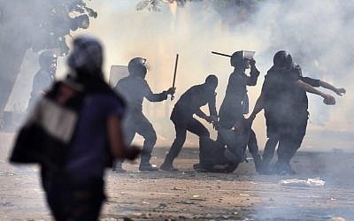 Egyptian security forces arrest a protester during clashes near Tahrir Square in Cairo, Egypt, Tuesday, November 27, 2012 (photo credit: AP/Khalil Hamra)