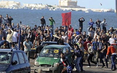 Protesters hurl stones during clashes between supporters and opponents of President Mohammed Morsi in Alexandria, Egypt, Friday, Nov. 23 (photo credit: AP/Tarek Fawzy)