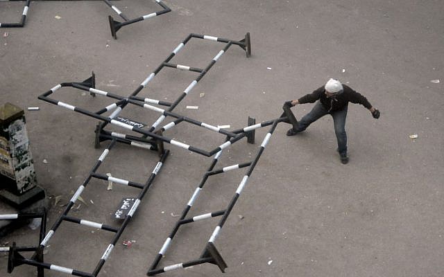 An Egyptian protester drags a security barrier during clashes outside the country's high court in Cairo, Egypt, Saturday, November 24, 2012 (photo credit: AP/Mohammed Asad)