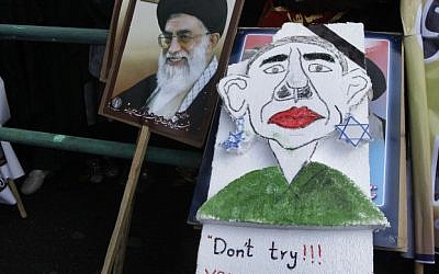 Iranian demonstrators, one holding a caricature of President Barack Obama next to a poster of Iranian Supreme Leader Ayatollah Ali Khamenei, attend an annual state-backed rally in front of the former US Embassy in Tehran, Iran, Friday, Nov. 2, 2012. (photo credit: AP)