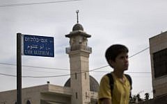 A child walks past the newly-named Umm Kulthum street in East Jerusalem, October 24, 2012 (photo credit: AP/Bernat Armangue)