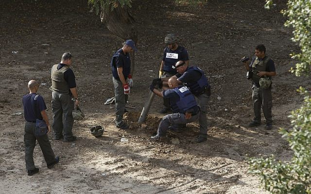 Police sappers remove the remains of a rocket fired by Gazans that landed in Ashkelon in November, 2012. (Photo credit: AP/Tsafrir Abayov) Police sappers remove the remains of a rocket fired by Gazans that landed in Ashkelon in November, 2012. (Photo credit: AP/Tsafrir Abayov)