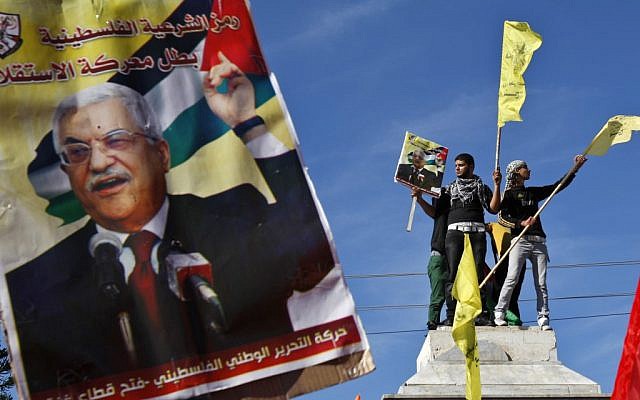 Palestinians wave Fatah flags behind a poster of Palestinian President Mahmoud Abbas during a rally in Gaza City, Thursday, Nov. 29 (photo credit: AP/Adel Hana)