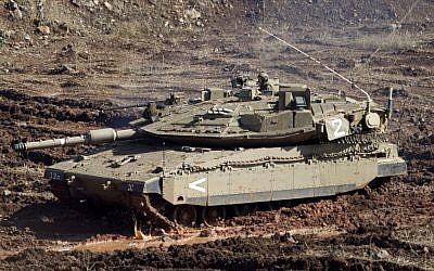 An IDF tank in a firing position on the Golan Heights last year (AP/Ariel Schalit)