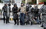 Jordanian policemen detain protesters blocking a main road during a demonstration against a rise in fuel prices in downtown Amman, Wednesday. (photo credit: AP/Raad Adayleh)