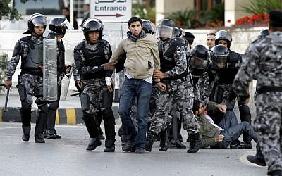 Jordanian policemen detain protesters blocking a main road during a demonstration against a rise in fuel prices in downtown Amman, Wednesday. (photo credit: AP/Raad Adayleh)