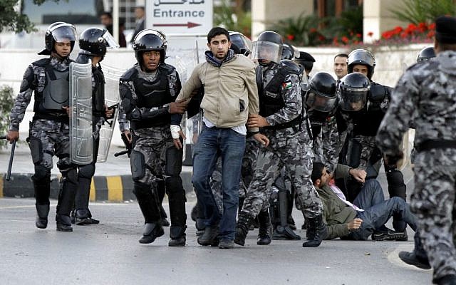 Jordanian policemen detain protesters blocking a main road during a demonstration against a rise in fuel prices in downtown Amman, Wednesday. (photo credit: AP/Raad Adayleh) Jordanian policemen detain protesters blocking a main road during a demonstration against a rise in fuel prices in downtown Amman, Wednesday. (photo credit: AP/Raad Adayleh)