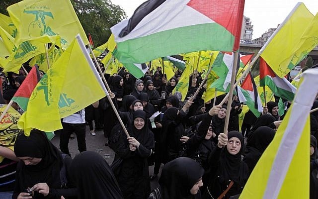 Hezbollah supporters wave Hezbollah and Palestinian flags during a demonstration against the Israeli offensive in Gaza near UN headquarters in Beirut, Lebanon, on Saturday, November 17, 2012 (photo credit: AP Photo/Bilal Hussein)