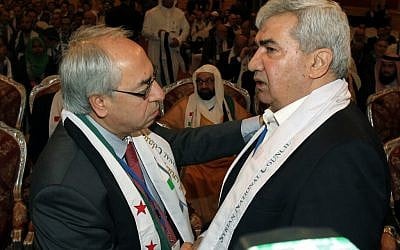 Syrian regime opponent Riad Seif, right, shakes hands with Syrian National Council chief Abdel Basset Seda during the meeting in Doha on Tuesday. (photo credit: AP/Osama Faisal) Syrian regime opponent Riad Seif, right, shakes hands with Syrian National Council chief Abdel Basset Seda during the meeting in Doha on Tuesday. (photo credit: AP/Osama Faisal)