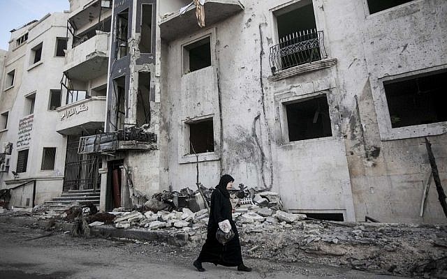 A Syrian woman walks in front of a destroyed hospital on the outskirts of Aleppo, Syria earlier this month (photo credit: AP/Narciso Contreras) A Syrian woman walks in front of a destroyed hospital on the outskirts of Aleppo, Syria earlier this month (photo credit: AP/Narciso Contreras)