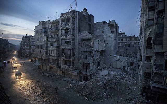 Nght falls on a Syrian rebel-controlled area as destroyed buildings, including Dar Al-Shifa hospital, are seen on Sa'ar street after airstrikes targeted the area last week, killing dozens in Aleppo, Syria (photo credit: AP/Narciso Contreras)