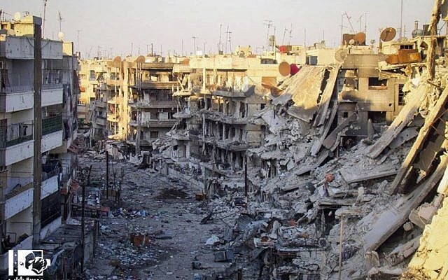 Buildings that were destroyed from the shelling by Syrian forces loyal to Syrian president Bashar Assad, at al-Qossour neighborhood in Homs province, central Syria. (photo credit: Lens Yong Homsi/AP)