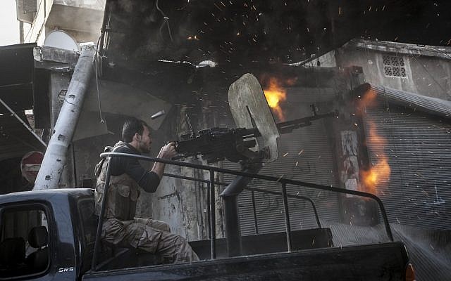 A member of the Syrian opposition fires at regime forces in Aleppo, Sunday (photo credit: Narciso Contreras/AP) A member of the Syrian opposition fires at regime forces in Aleppo, Sunday (photo credit: Narciso Contreras/AP)