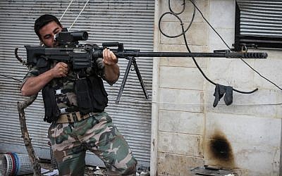 A rebel fighter poses for a photographer while holding a Russian weapon acquired from the Syrian army by Free Syrian Army rebels in the northwestern city of Maraat al-Numan, Syria, on Saturday, Nov. 17, 2012. (Mustafa Karali/AP)