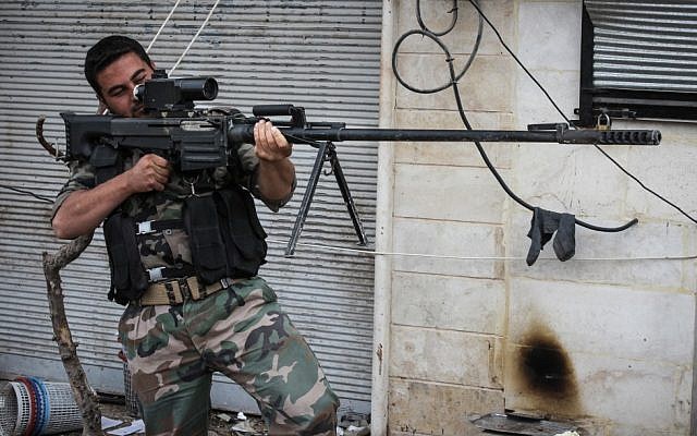 A rebel fighter poses for a photographer while holding a Russian weapon acquired from the Syrian army by Free Syrian Army rebels in the northwestern city of Maraat al-Numan, Syria, on Saturday, Nov. 17, 2012. (Mustafa Karali/AP)
