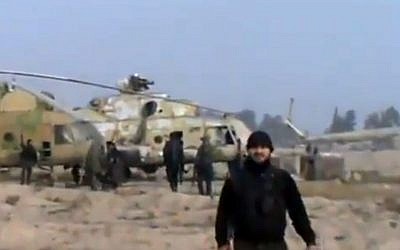 This video image shows Syrian rebels with a captured helicopter at an air base near the capital Damascus in November, 2012 (photo credit: AP Photo/Ugarit News via AP video)