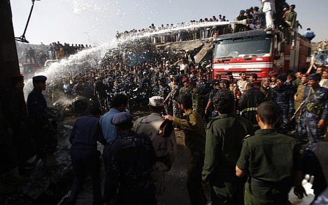 Firefighters work to extinguish a fire at the wreckage of a plane after it crashed in Sanaa, Yemen, on Wednesday, November 21, 2012 (photo credit: AP Photo/Hani Mohammed)