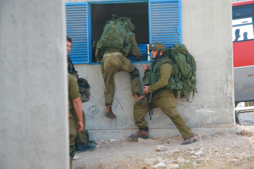A soldier training for the Gaza Strip, helping a buddy through the window of home (Photo credit: Alon)