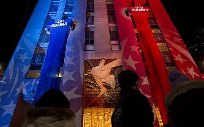 People watch early election results displayed on a utility lift suspended from the front of the GE Building at Rockefeller Center New York, Tuesday, Nov. 6 (photo credit: AP/Craig Ruttle)