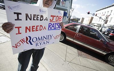 John DeNoyelles, from Flint, Texas, who said he is in Ohio trying to network to find a job, holds a sign in support of Mitt Romney along Main Street in Bowling Green, Ohio Monday Nov. 5, 2012. (photo credit: J.D. Pooley/AP)