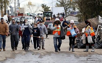 Volunteers walk toward homes to help residents clean up, Saturday, Nov. 3, 2012, in Staten Island, N.Y. (photo credit: AP/Julio Cortez)
