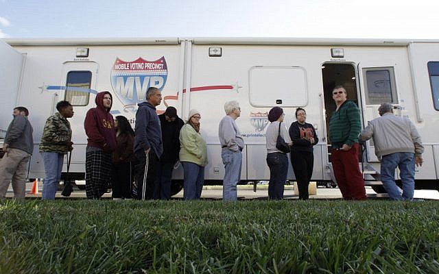People, many displaced by superstorm Sandy, line up to vote Monday, Nov. 5, 2012, in Burlington, N.J., at a Mobile Voting Precinct. Many victims displaced by the storm are taking advantage of offers to vote early (photo credit: AP Photo/Mel Evans) People, many displaced by superstorm Sandy, line up to vote Monday, Nov. 5, 2012, in Burlington, N.J., at a Mobile Voting Precinct. Many victims displaced by the storm are taking advantage of offers to vote early (photo credit: AP Photo/Mel Evans)