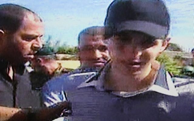 Israeli soldier Gilad Shalit (center) on the day he was released in a prisoner exchange, October 18, 2011. Hamas military leader Ahmed Jabari can be seen directly behind his right shoulder. (photo credit: Flash90)
