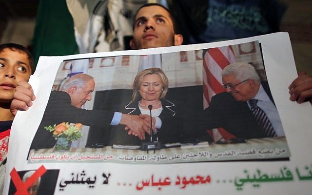 A protester in Gaza carries a sign reading 'I am a Palestinian -- Abbas doesn't represent me,' in a rally organized by Hamas on November 3 (photo credit: Wissam Nassar/Flash90)
