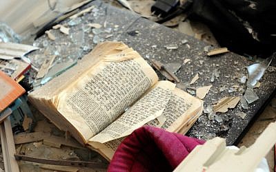 A Bible covered with debris in a Kiryat Malachi apartment in which three people were killed from a rocket attack on Thursday (photo credit: Yossi Zeliger/Flash90)