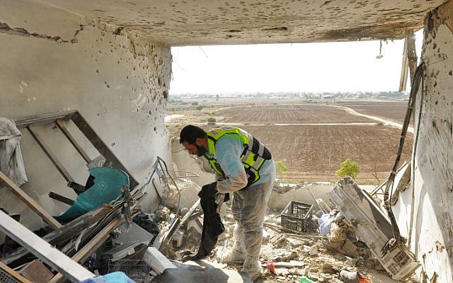 A ZAKA volunteer looks for human remains in the Kiryat Malachi apartment where three Israelis were killed by a rocket fired from Gaza Thursday, November 15 (photo credit: Yossi Zeliger/Flash90) A ZAKA volunteer looks for human remains in the Kiryat Malachi apartment where three Israelis were killed by a rocket fired from Gaza Thursday, November 15 (photo credit: Yossi Zeliger/Flash90)