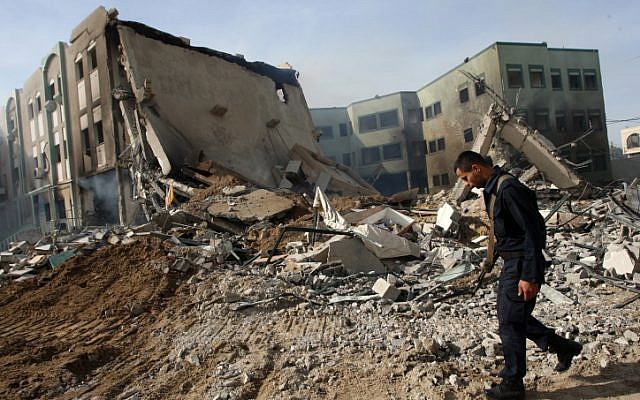 Hamas security members inspect a destroyed government building after an Israeli airstrike in Gaza City on November 16 (photo credit: Abed Rahim Khatib/Flash90)