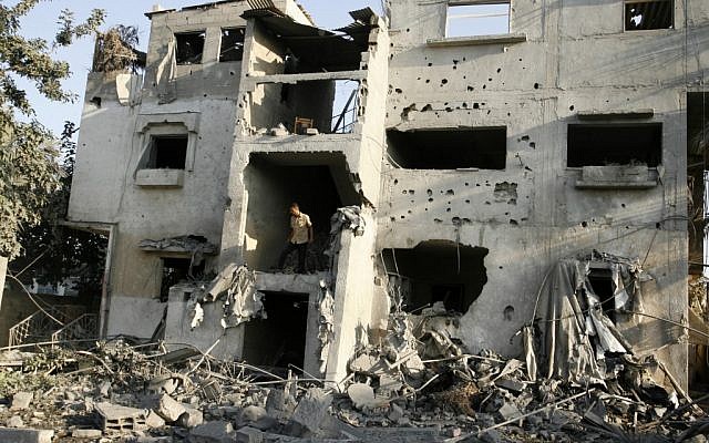 Palestinians inspect damaged buildings following overnight Israeli air strikes on the southern Gaza Strip town of Rafah on November 20, 2012 (photo credit: Abed Rahim Khatib / Flash 90)