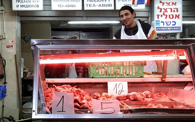 Illustrative: A butcher at the Carmel Market in Tel Aviv (Photo credit Nicky Kelvin/Flash90)