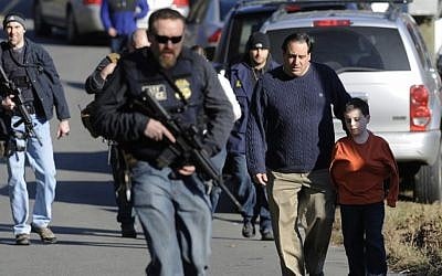 Parents leave a staging area after being reunited with their children following a shooting at the Sandy Hook Elementary School in Newtown, Conn., about 60 miles (96 kilometers) northeast of New York City, Friday, Dec. 14 (photo credit: AP/Jessica Hill)