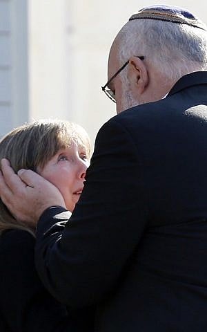 Two people embrace following a service at the Congregation Adath Israel in Newtown, Conn., on Saturday. (photo credit: AP/Charles Krupa)