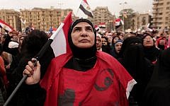 An Egyptian woman holds a national flag as she listens to speakers, not pictured, in Tahrir Square in Cairo, Egypt, Tuesday, Dec. 4, 2012 (photo credit: AP/Maya Alleruzzo)