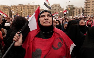 An Egyptian woman holds a national flag as she listens to speakers, not pictured, in Tahrir Square in Cairo, Egypt, Tuesday, Dec. 4, 2012 (photo credit: AP/Maya Alleruzzo)