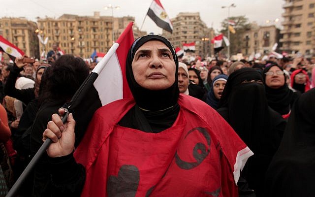 An Egyptian woman holds a national flag as she listens to speakers, not pictured, in Tahrir Square in Cairo, Egypt, Tuesday, Dec. 4, 2012 (photo credit: AP/Maya Alleruzzo)