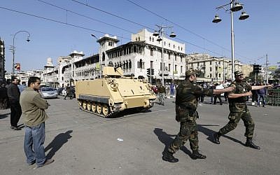 Egyptian Army deploy near the presidential palace to secure the site of overnight clashes between supporters and opponents of President Mohammed Morsi in Cairo on Thursday. (photo credit: AP/Hassan Ammar)